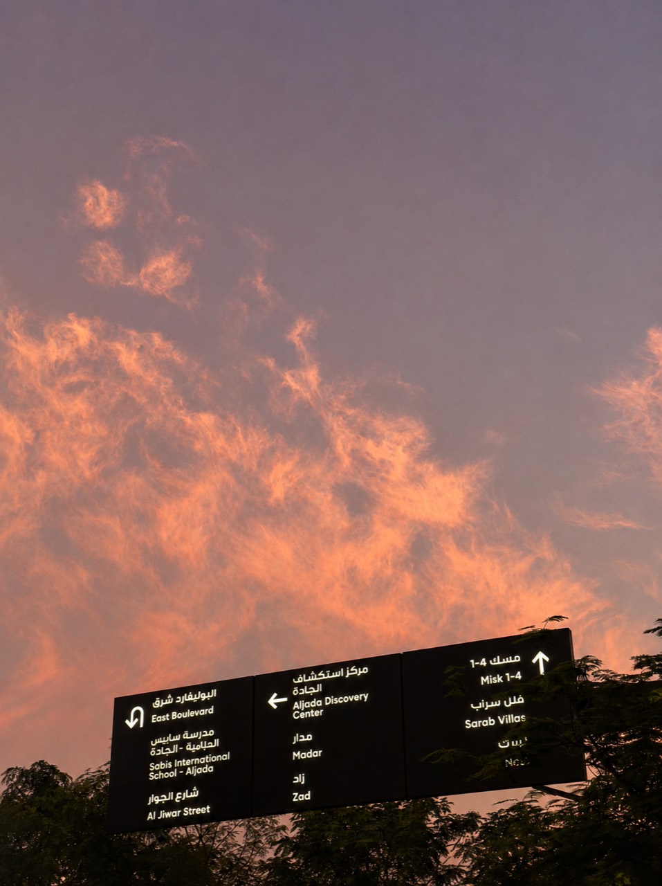 Warm sunset clouds over city wayfinding signs