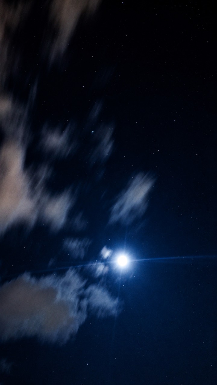 Moonlit night sky with clouds and stars