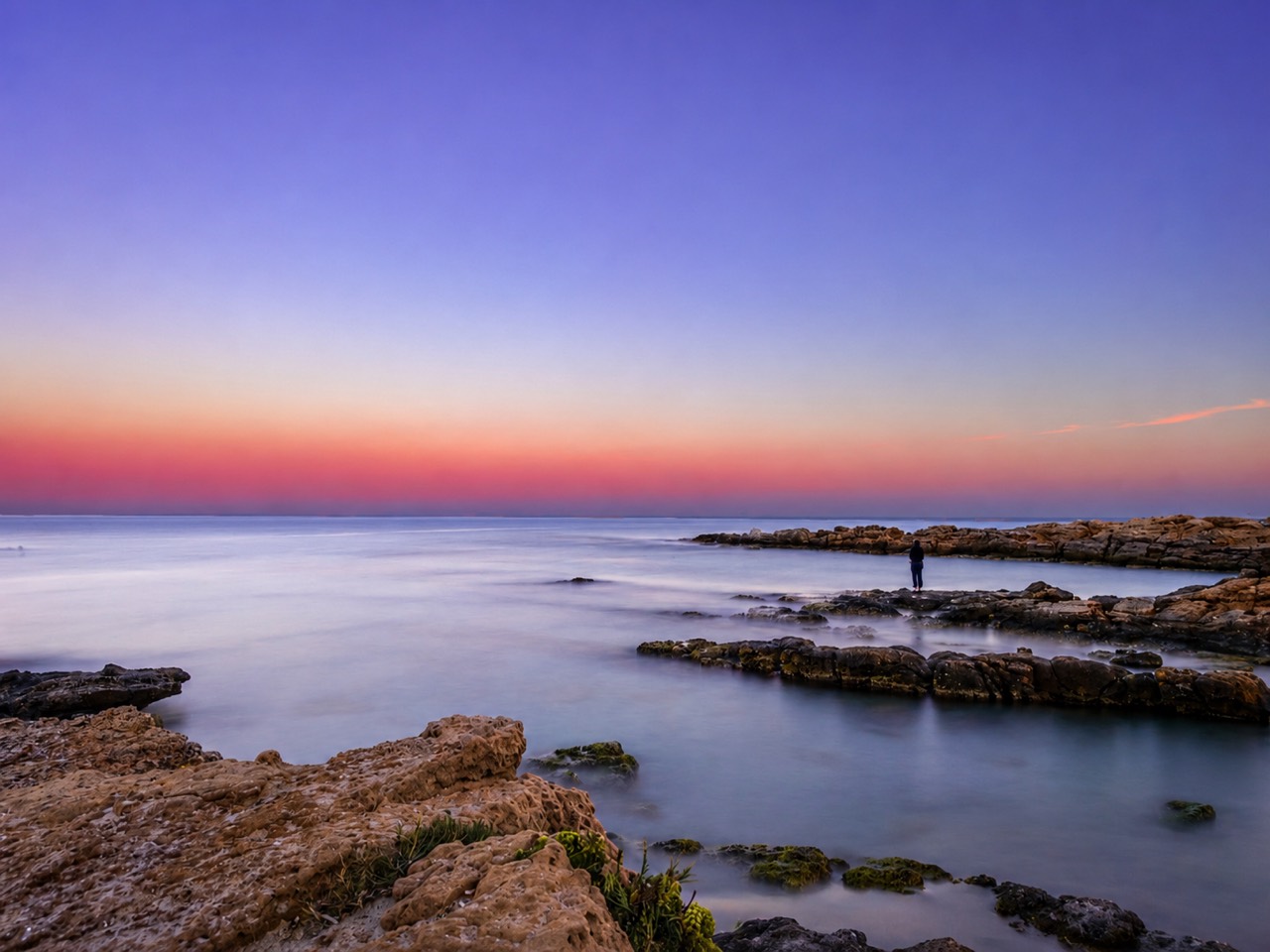 Long-exposure rocky coastline at dusk